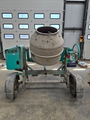 a cement mixer sitting on a dolly in a garage