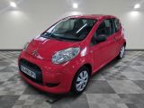 la petite voiture rouge est garée sur un sol en damier