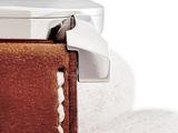 a close up of a watch with a brown leather strap