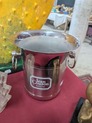 un seau à glace en argent posé sur une table rouge