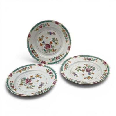three plates with floral designs on them on a white surface