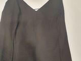 the back of a black dress hanging on a hanger