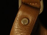 a close up of a brown leather bag with a metal clasp