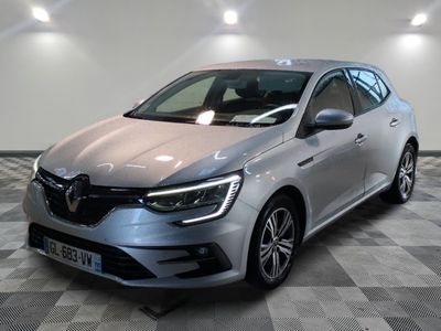 une voiture argentée est garée dans une grande pièce au sol en damier