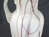 a white vase with red lines on it on a black background