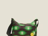 a green and white polka dot print bag with a black strap