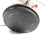 a person holding a frying pan on a white surface