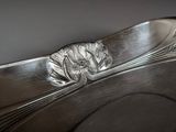 a silver plate with a flower on it