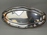 an oval silver tray with a mirror on top of it