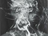 photographie en noir et blanc d'un homme dont de la fumée sort de la bouche