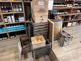 il y a de nombreuses caisses de vin par terre dans ce magasin