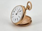 an antique pocket watch sitting on top of a white surface