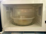 a white microwave with a bowl inside of it