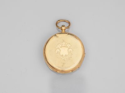 une vieille montre de poche en or avec une chaîne, posée sur une surface blanche