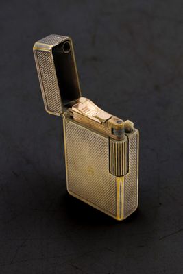 briquet doré posé sur une surface noire, avec un briquet au centre
