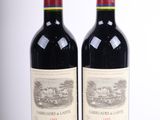 deux bouteilles de vin rouge posées l'une à côté de l'autre sur une surface blanche