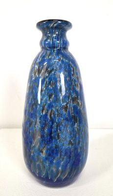 a blue vase that is sitting on a white surface