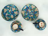 trois tasses et soucoupes posées sur une table, ornées de fleurs