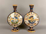 pair of blue and gold vases with a picture of a man riding a horse