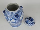 a blue and white vase with a lid next to it