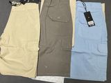 three pairs of men ' s cargo shorts with tags on them