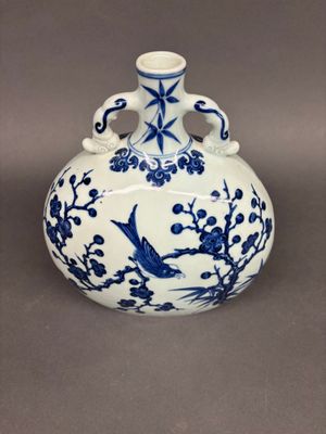 a blue and white vase with a bird on it