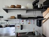 a kitchen with a sink, stove, and shelves in it