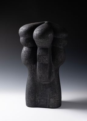 sculpture représentant deux mains qui se tiennent l'une l'autre, sur une photo en noir et blanc