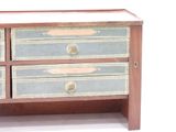 a small wooden chest with three drawers on it