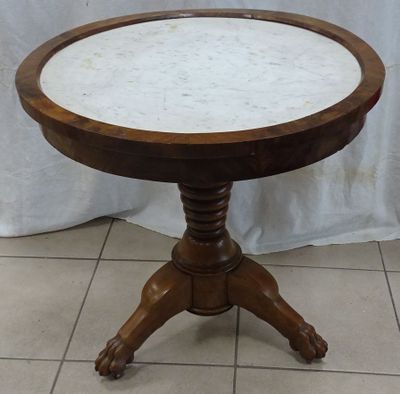 marble topped table with wooden pedestal on tiled floor in front of a white curtain