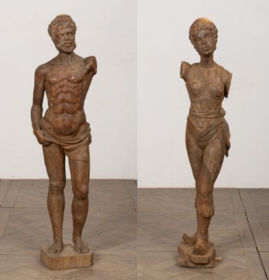 a pair of wooden sculptures of a man and a woman