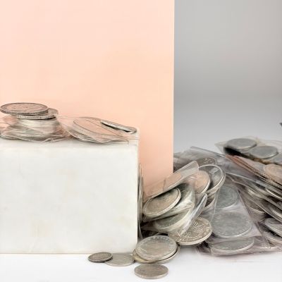 a box of coins sitting next to a pile of coins