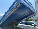 a blue dumpster sitting on the back of a truck
