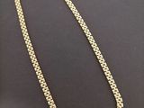 a gold chain with a diamond clasp on a black background