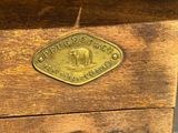 an old wooden box with a brass plate on top of it