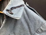 a jacket hanging on a wooden hanger on a wall