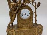a gold clock with an angel on top of it