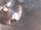 a close up of a metal bowl with a hole in it