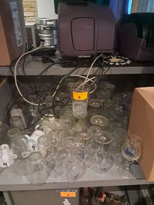 de nombreux verres vides posés sur une étagère dans une pièce