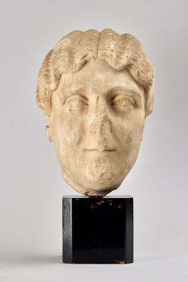 marble head of a woman with curly hair on a black stand