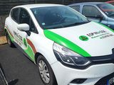 a white car with a green and white stripe parked in a parking lot