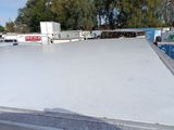 a skateboarder doing a trick on a ramp in a parking lot