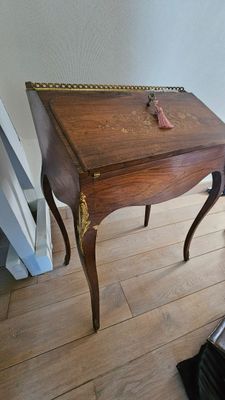 une petite table en bois sur laquelle est posée une horloge