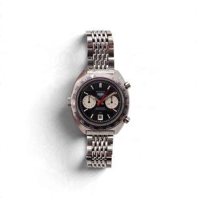 un gros plan d'une montre sur une surface blanche avec un fond blanc