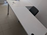 un bureau blanc avec une chaise noire dans une pièce
