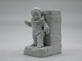 a small statue of a child on a stone block