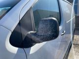 the side view mirror of a car is covered in a lot of snow