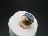 an image of a gold ring with a blue stone on it