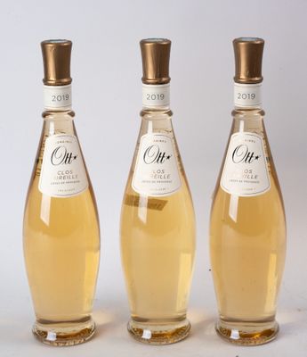 trois bouteilles de vin posées les unes à côté des autres sur une surface blanche