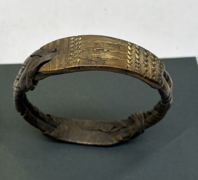 gros plan d'un bracelet en or sur une surface noire